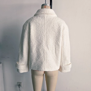 Rear view of a white sherpa fleece jacket with a classic collar on a display mannequin