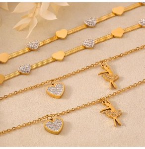 Detailed macro view of gold-plated heart charms and ballerina pendant on elegant bracelets