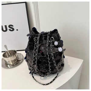Macro shot of black sequin bucket bag featuring silver metal chain and leather strap