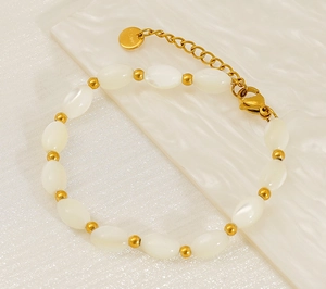 Detail of 18K gold stainless steel bracelet with baroque pearls and S.Steel logo tag