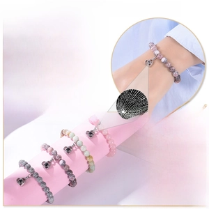 Macro detail of 8mm pink zebra stone beads and heart-shaped projection pendant bracelet