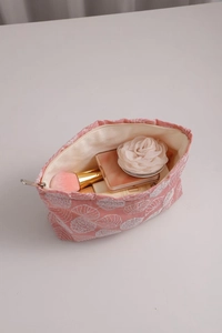 Detailed interior view of pink floral cotton linen makeup bag with cosmetics and brushes
