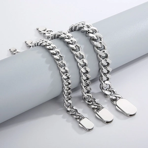 Close-up of three silver Cuban chain bracelets in different sizes on a grey stand