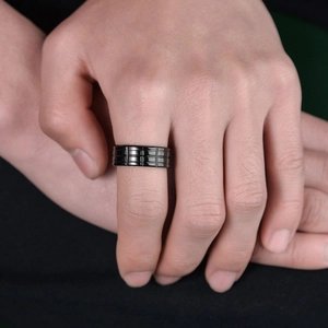 Men's black stainless steel ring with textured grid pattern displayed on a hand