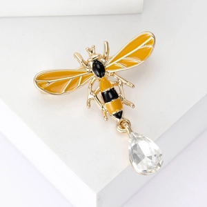 Detail of bee brooch with yellow enamel wings and teardrop crystal pendant in gold finish