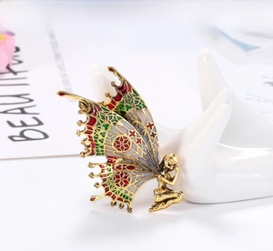 Detail of vintage butterfly fairy brooch with colorful enamel and golden finish