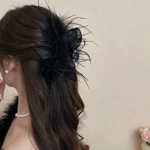 Detail showing elegant black feather and mesh hair claw clip on model hair back view