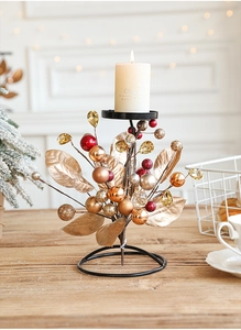 Close-up of European Christmas candle holder with golden leaves and red ornaments