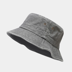 Detail view of grey washed cotton bucket hat showing metal ventilation eyelets and texture
