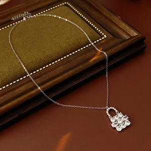 Dettaglio di collana con ciondolo a fiore in argento e zirconi su velluto verde