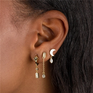 Macro shot of gold-plated earring set featuring star and moon charms with cubic zirconia