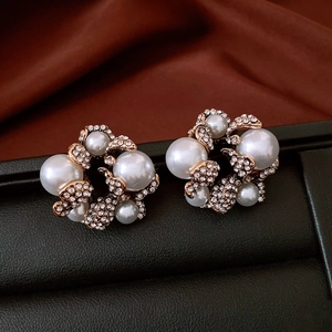 Dettaglio macro di orecchini a fiore vintage con eleganti perle e strass scintillanti