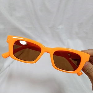 Detail view of stylish orange rectangular frames and tinted lenses for women
