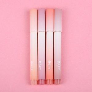 Macro detail of four gradient highlighters with soft matte finish on a pink background