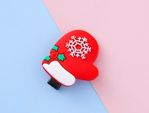 Détail d'une pince à cheveux gant de Noël avec flocons de neige et feuilles de houx