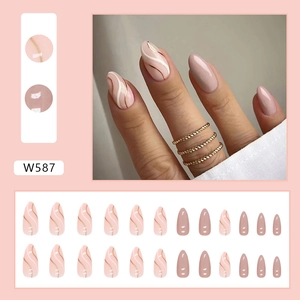 Macro detail of almond pink press-on nails with white and gold wavy patterns