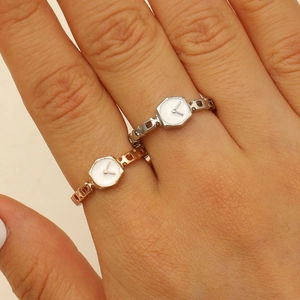 Macro view of adjustable watch-style rings in silver and rose gold finishes on finger