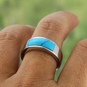 Macro detail of men's stainless steel ring featuring a rectangular blue turquoise stone