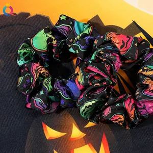 Detailed view of Halloween scrunchie with skull and pumpkin prints on soft fabric