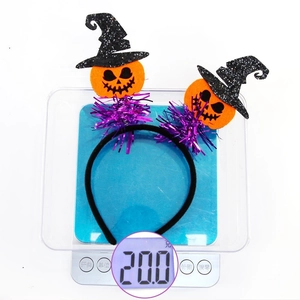 Halloween headband with orange pumpkin and witch hat decorations weighing 20g on a scale