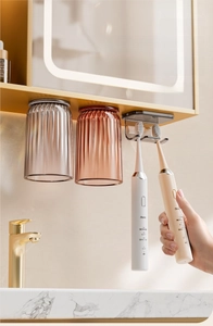 Detail of magnetic toothbrush holder with translucent ribbed cups mounted under a cabinet