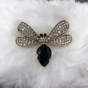 Antique gold dragonfly brooch with crystals and black water-drop zircon on white fur