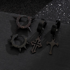 Macro view of 4-piece black punk earrings set with spikes and crosses on leather