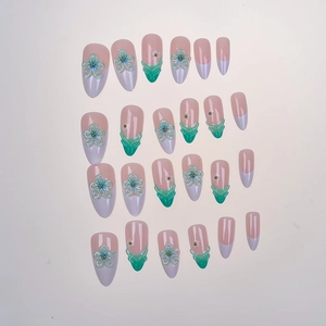 Macro view of 3D embossed floral patterns on almond-shaped press-on nails in mint green