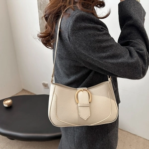 Detail view of the cream white underarm bag with lychee texture and gold metal buckle