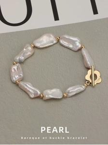 Macro detail of natural Baroque freshwater pearls and golden flower OT buckle clasp