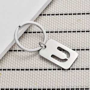 Close-up of brushed silver metal keychain featuring hollowed out letter U on army tag