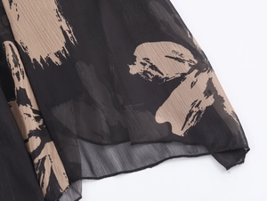 Detailed view of lightweight chiffon skirt hem with artistic brushstroke print and rolled edge
