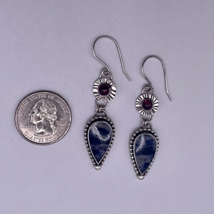 Macro shot of vintage teardrop enamel earrings with red gemstone and blue stone inlay