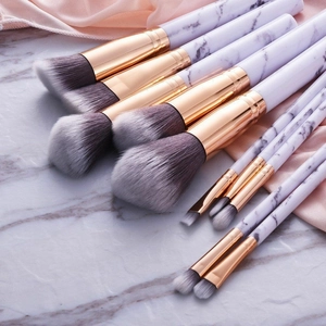 10-piece marble texture makeup brush set with rose gold accents on pink silk backdrop