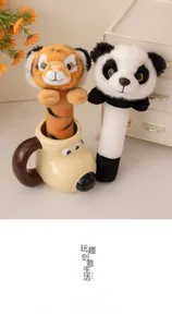 Plush animal massage stick featuring tiger and panda head designs on a cozy desk