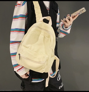 Detail des hellgelben Canvas-Rucksacks mit Metallreißverschluss und Stoffstruktur