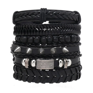 Close-up of multi-layer black leather bracelets with woven beads and metal studs set