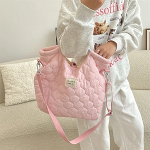 Détails du sac cabas en toile matelassée rose avec bandoulière et fermeture à pression