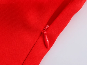 Vue macro de la fermeture éclair invisible rouge sur la robe courte à volants rouge