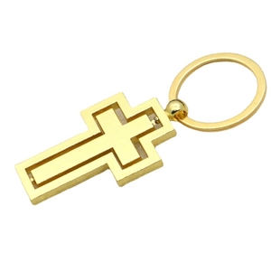 Rotating gold metal cross keychain for car bags and accessories on white background