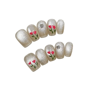 Pink tulip press-on nails with light gold cat-eye glitter and silver heart rhinestones