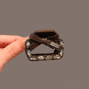 Brown leather bow hair claw clip with rhinestones and elegant gold-tone metal base