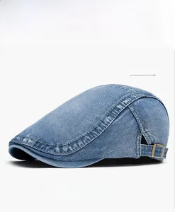 Detail of blue washed denim flat cap with adjustable metal buckle and contrast stitching