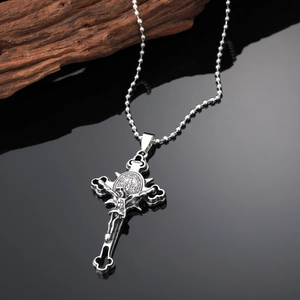 Punk style antique silver cross necklace with pearl chain on a dark reflective surface