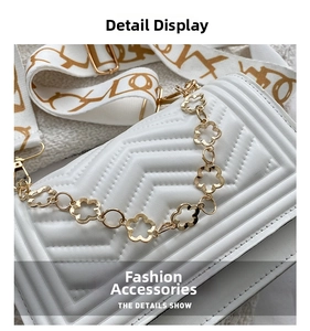 Detail of white quilted crossbody bag with golden flower chain and woven strap