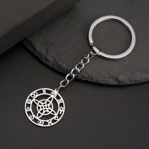 Macro detail of silver stainless steel moon pendant with mystic runes on rock surface