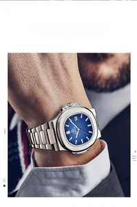 Macro shot of silver steel watch with blue striped dial and date window on model wrist