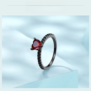 Macro detail of Gothic heart ring featuring a red zircon in black plated silver