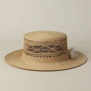 Detail eines Raffia-Sonnenhuts mit Hohlwebmuster und elegantem Perlenblumen-Akzent