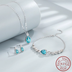 Detailed set of S925 silver necklace, earrings and bracelet with blue teardrop gems
